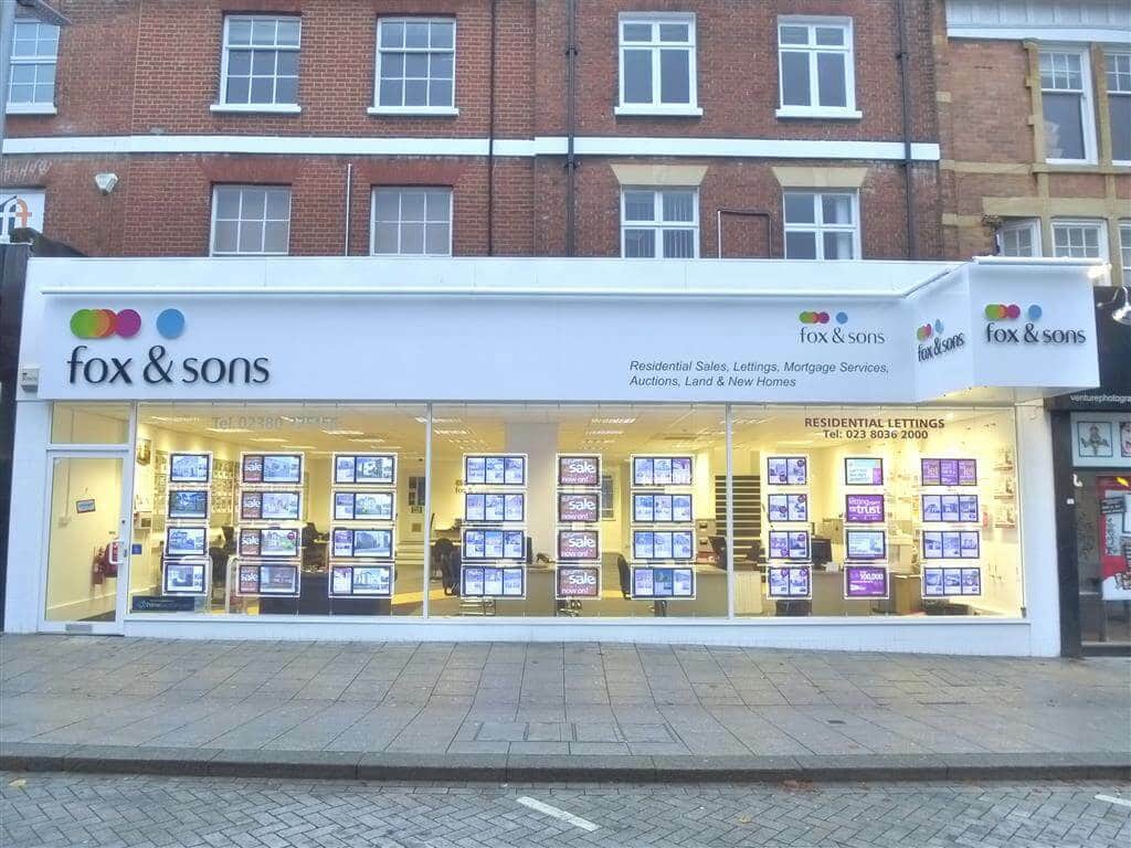 Estate agency shopfront with property listings in the window