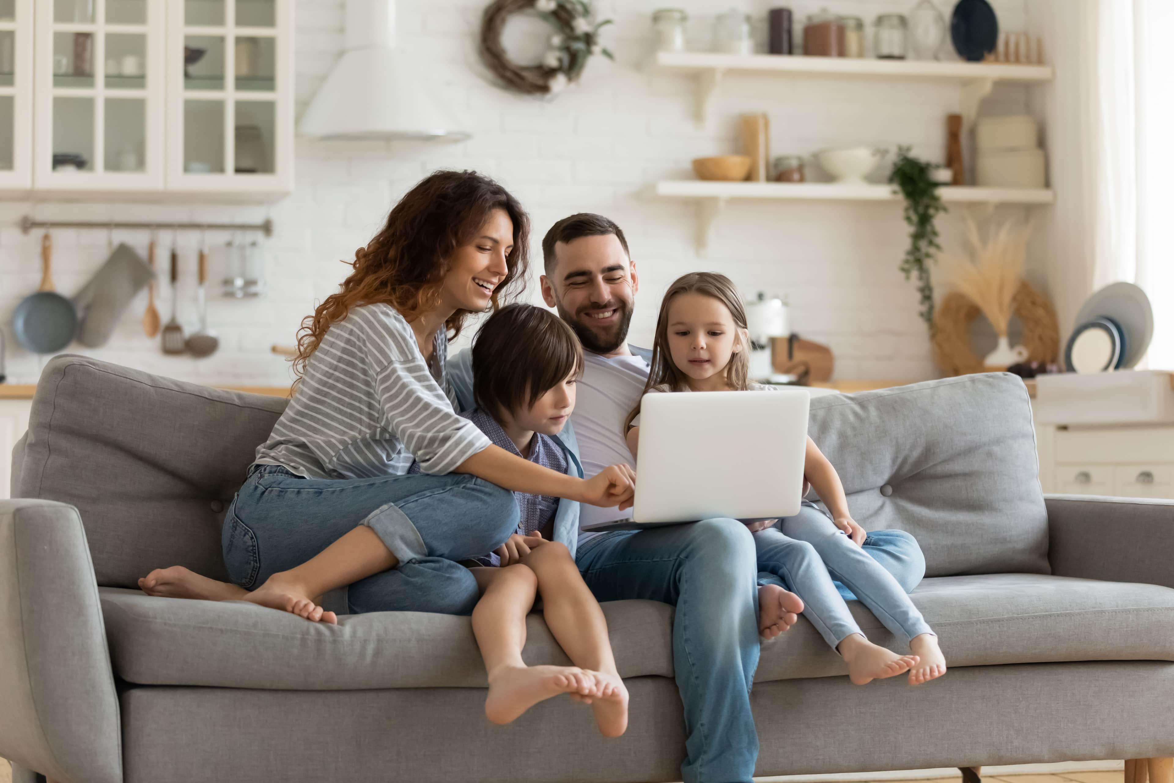Family on a sofa looking at a laptop together