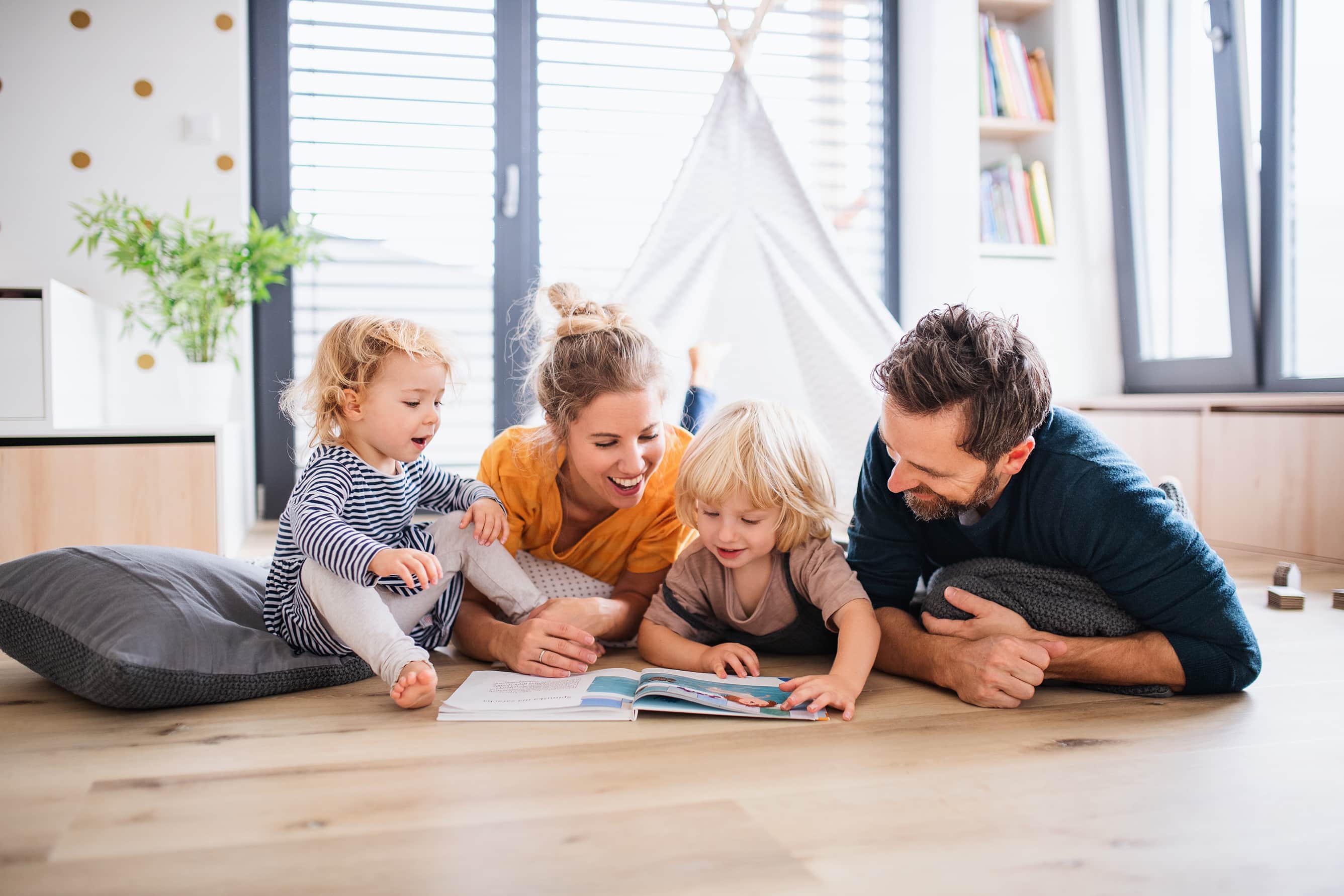 Family reading together on the living room floor