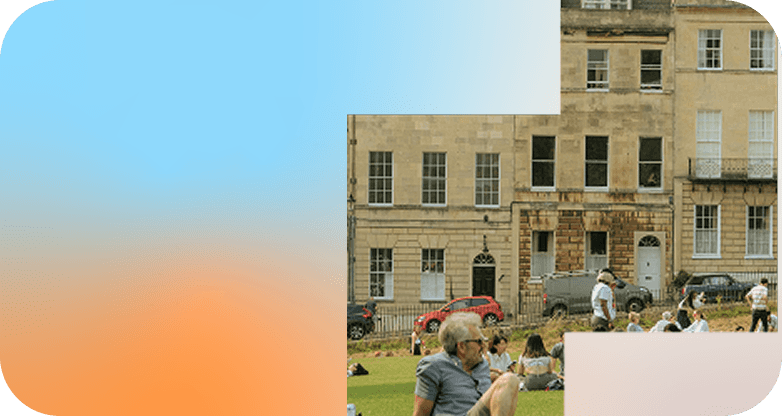 People relaxing on the grass in front of a Georgian stone terrace